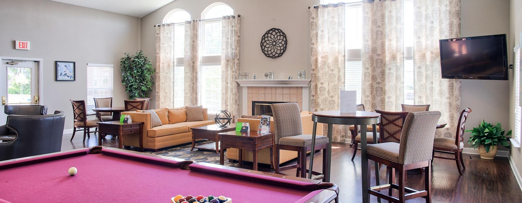 a room with a pool table and chairs